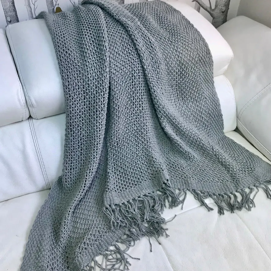 Open knit tasseled throw